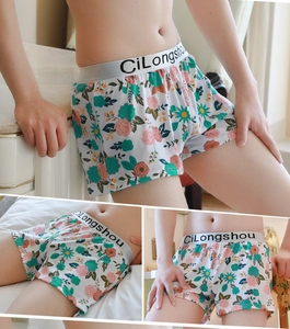 Detail view of men loose floral print boxer shorts with gray elastic logo waistband
