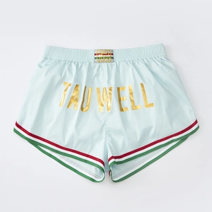 Detail of light blue sports shorts with TAUWELL gold print and tricolor striped edge