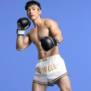 Close-up of Muay Thai shorts featuring a wide elastic waistband and gold brand lettering