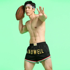 Macro shot of men's athletic shorts featuring Tauwell logo and elastic striped waistband