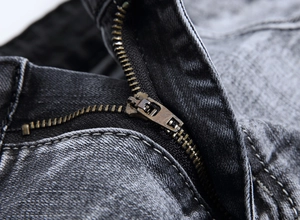 Gros plan sur la fermeture éclair en métal et les coutures d'un jean gris pour homme
