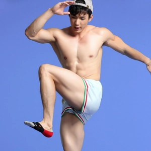 Detail of light blue sports shorts with striped hem and patterned low-cut socks