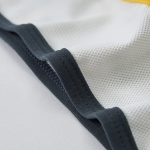 Detail of breathable white mesh fabric with grey trim and yellow accents on underwear