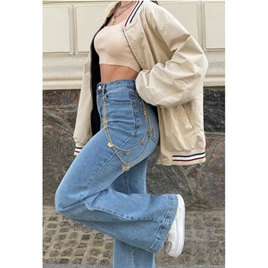 Detail of high waisted flare jeans in light blue denim with golden butterfly waist chain