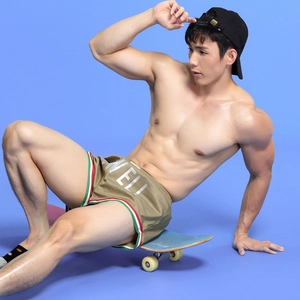 Detail of khaki men's satin sports shorts with side stripes and MELI printed design