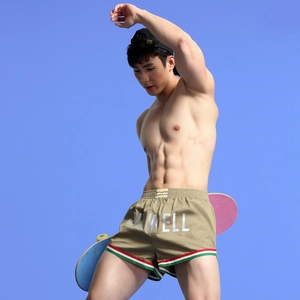 Close-up of khaki athletic shorts with striped hems and skateboarder style detail