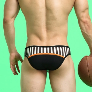 Detail of men's low-rise briefs featuring striped pattern and orange contrast waistband