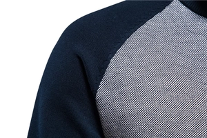 Détail du pull en tricot pour homme avec manches raglan contrastées bleu marine et gris