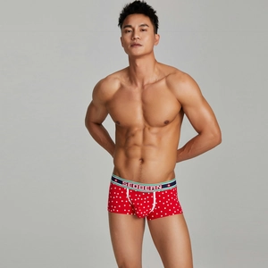 Detail view of red boxer briefs featuring white star patterns and a striped elastic waistband