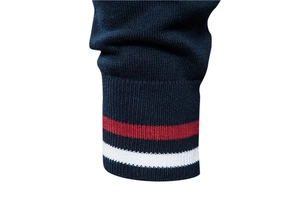 Détail du poignet en tricot bleu marine avec rayures rouges et blanches de haute qualité