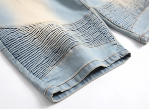 Men's light blue biker denim shorts with pleated knee detail and washed finish