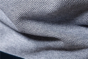Détail macro du tissu en maille bicolore montrant une texture géométrique de qualité