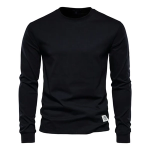 Close-up of black cotton long sleeve T-shirt featuring ribbed cuffs and a side woven label