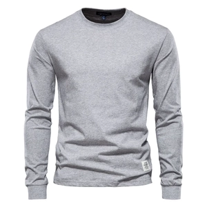 Close-up of light grey crewneck tee featuring ribbed cuffs and a white woven hem label