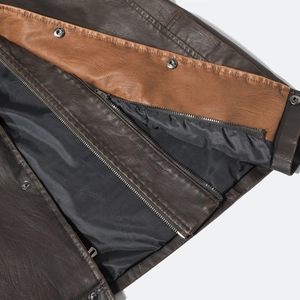 Detail of brown PU leather vest showing stitching, silver snap buttons and black zipper