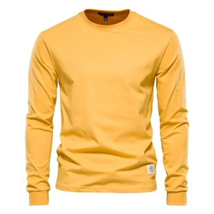 Detail of knit fabric texture and logo label on ginger yellow long sleeve crew neck t-shirt
