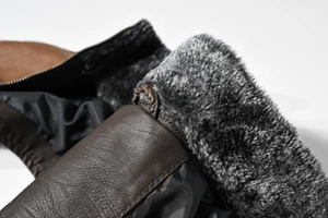 Close-up of brown PU leather texture and thick grey faux fur lining on men's vest jacket