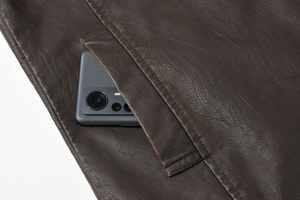 Detail of dark brown PU leather vest showing large functional pocket with a smartphone