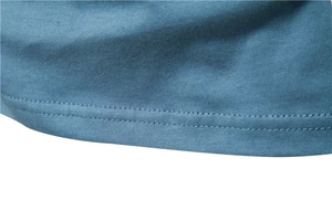 Macro detail of high-quality double-needle stitching on blue knit shirt hemline