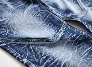 Detail of men's straight jeans showing dark blue snowflake wash and back pocket stitching