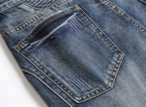 Macro shot of back pocket stitching and whiskered denim texture on blue jeans