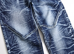 Detailed close-up of men's straight jeans showing heavy wash and double stitching