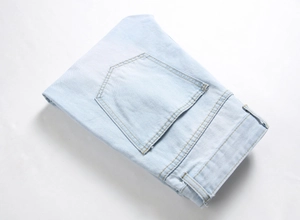 Close-up of light blue distressed denim jeans with back pocket stitching and fabric texture