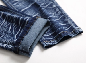 Close-up of men's straight jeans showing the washed denim cuff with wave pattern texture