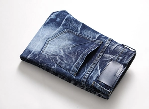 Detail view of men's straight jeans showing snow wash texture and leather waist label