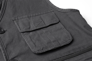 Détail de la poche à rabat avec bouton sur un gilet en toile gris foncé robuste