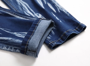 Detailed macro view of men's blue denim jeans hem with orange contrast stitching