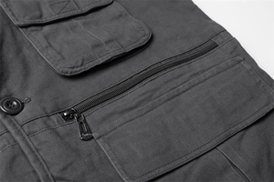 Détail du design multi-poches avec fermeture éclair sur ce gilet de travail gris