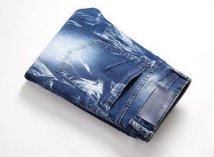 Detail of stone washed denim texture with blue leather patch and fashion engraving
