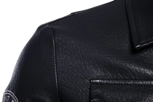 Close-up of black leather jacket with lychee grain texture and embroidered patch detail
