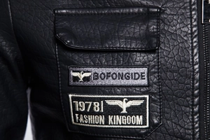 Detailed macro view of litchi texture leather jacket with embroidered patches and pockets