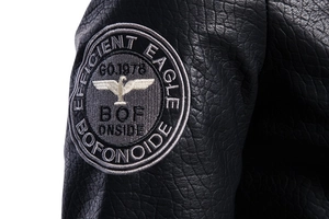 Macro view of eagle embroidery patch on black pebbled leather motorcycle jacket sleeve