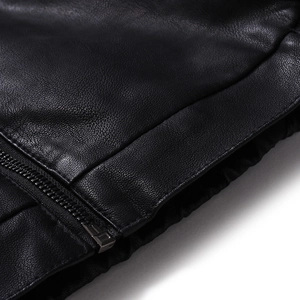 Detailed close-up of high-quality black leather texture with a durable gunmetal zipper