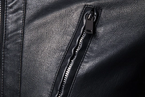 Gros plan sur la texture du cuir noir grainé et la fermeture éclair métallique de qualité