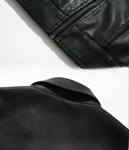 Detailed close-up of black PU leather jacket showing litchi texture and metal zipper hem