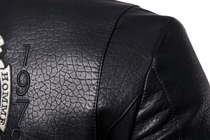 Detail of vintage embroidery and cracked leather texture on men's motorcycle jacket