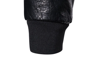 Detailed macro view of black faux leather jacket cuff with ribbed elastic knitting