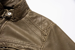 Close-up of diamond quilting on shoulders and snap button of a brown vintage leather jacket