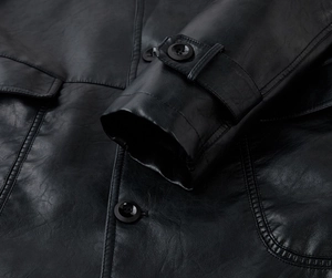 Close-up of black PU leather jacket featuring cuff adjustment straps and button details