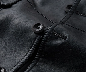 Macro view of leather texture and resin button on black long men's PU jacket