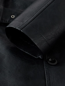 Close-up of black PU leather sleeve showing detailed texture and metallic eyelet buttons