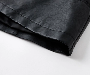 Close-up of black PU leather jacket hem showing fine stitching and litchi texture details