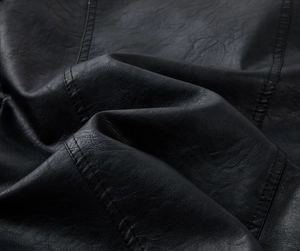 Close-up of black PU leather texture with fine stitching and matte finish for men jacket