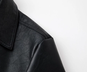 Close-up of the black PU leather texture and neat stitching on the lapel and shoulder