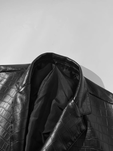 Detail of men's faux leather blazer showing crocodile texture and wide lapel collar