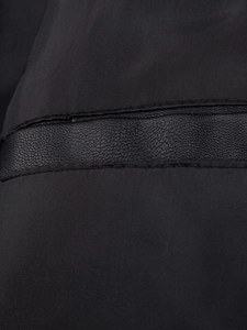 Close-up of black PU leather texture with neat stitching on casual men's jacket